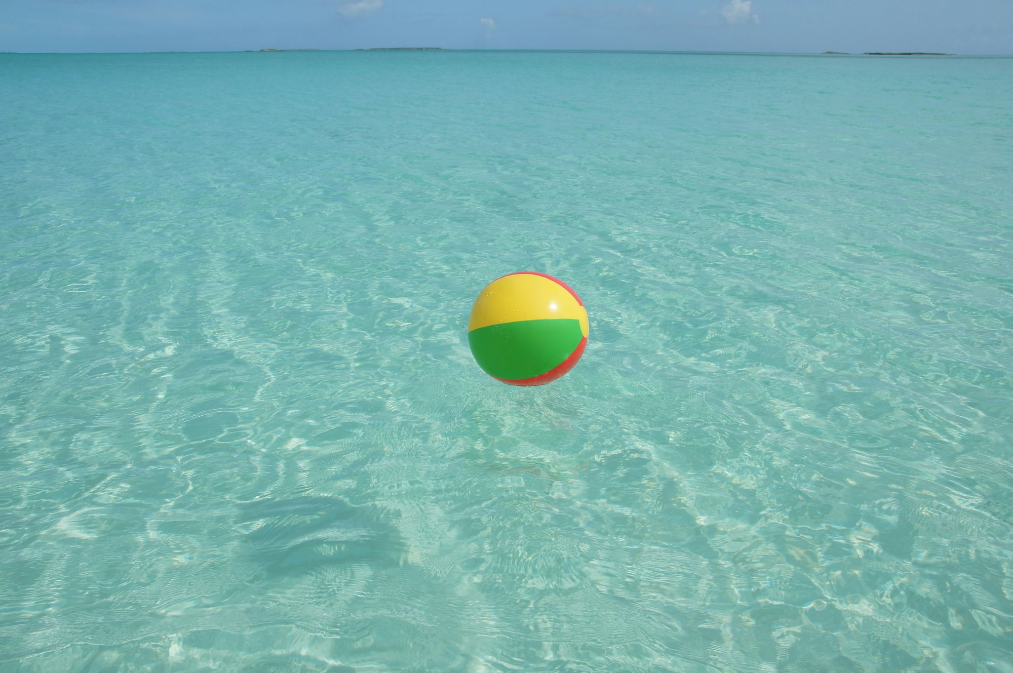 Colourful beachball on a clear blue sea
